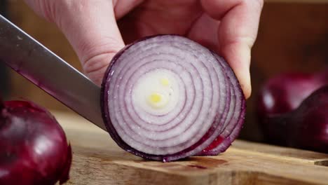 hands men cut red onion in rings.