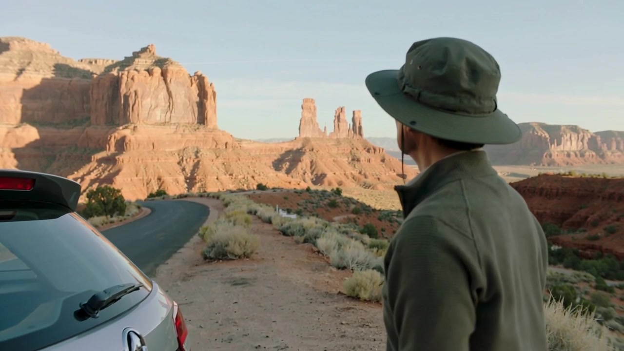 Hombre con chaqueta verde y sombrero cerrando la escotilla mientras revisa un mapa de papel, observando mesetas, espacio para texto.