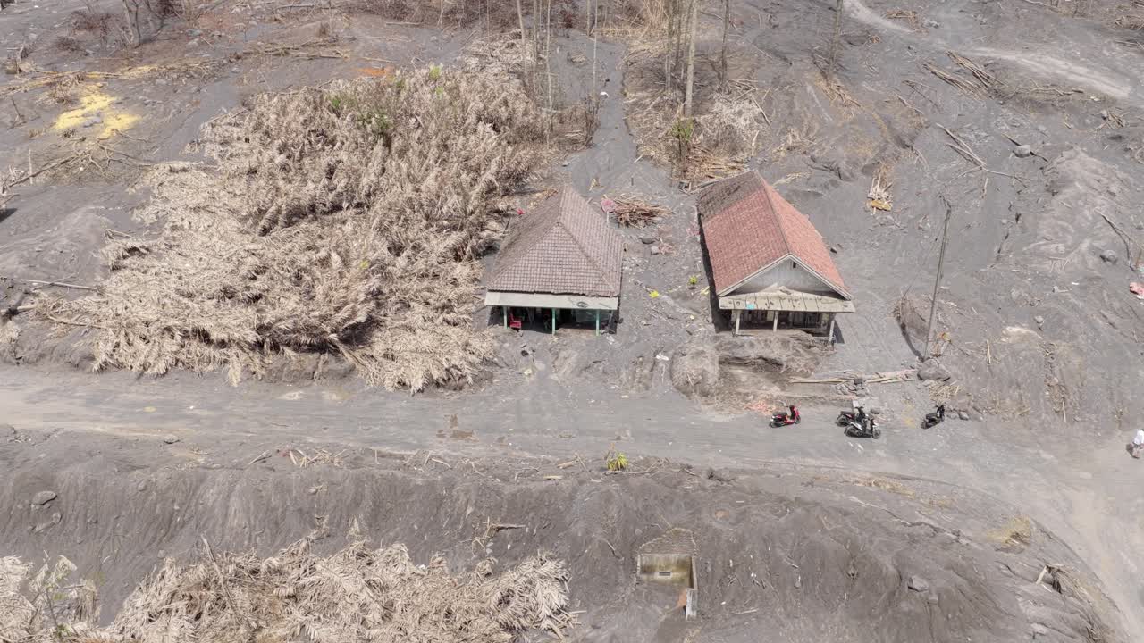 Conseguenze dell'eruzione del vulcano Semeru con case seppellite dalla cenere lavica.
