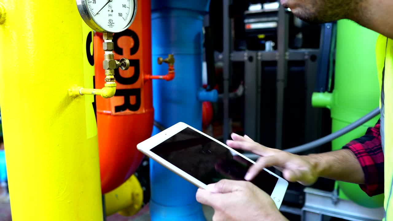 мужские азиатские инженеры проверяют газовую систему завода.