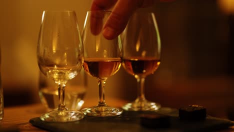 hand reaching for whisky glass on tray