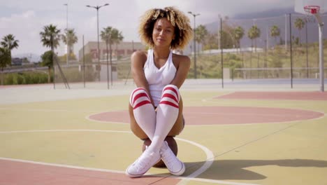 Atractiva-Mujer-Joven-Sentada-En-Una-Pelota-De-Baloncesto