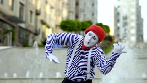 funny mime playing at violin at fountains background