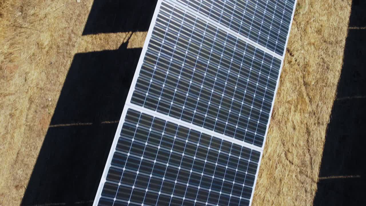 Vista aerea dall'alto di un campo di pannelli solari in una centrale fotovoltaica in una giornata di sole.