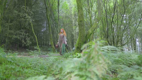 Girl-walking-along-shady-forest-path-in-summer-low-angle-view-at-half-speed-slow-motion