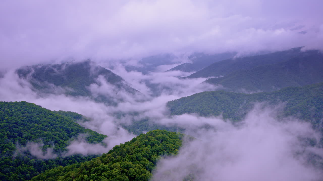 Drone camera floats above a fog-draped Smoky landscape