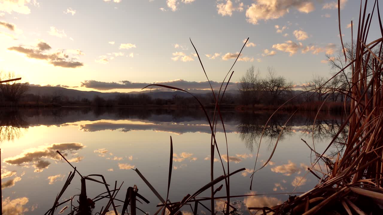 reflejo de la puesta de sol y las nubes sobre la superficie del lago