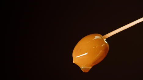 caramel-glazed olive on a stick