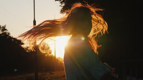 a child frolics on the street in the evening when the sun sets runs and jumps emotionally