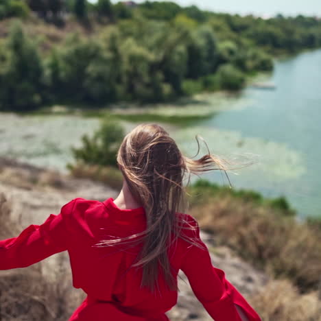 long haired woman on the natural summer background. beautiful young lady walking down the hill to the river in a sunny day. slow motion.