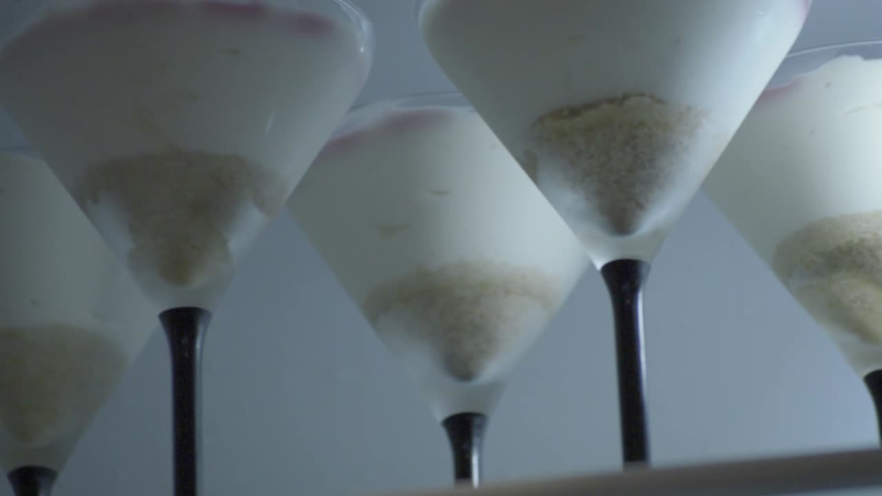 바닥에 부서진 비스킷이 있고 상단에 젤리 과일이 있는 유리에 크림 치즈 케이크, 패닝