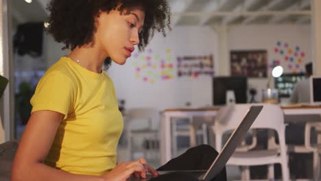 Mixed-race-woman-on-computer-in-creative-office