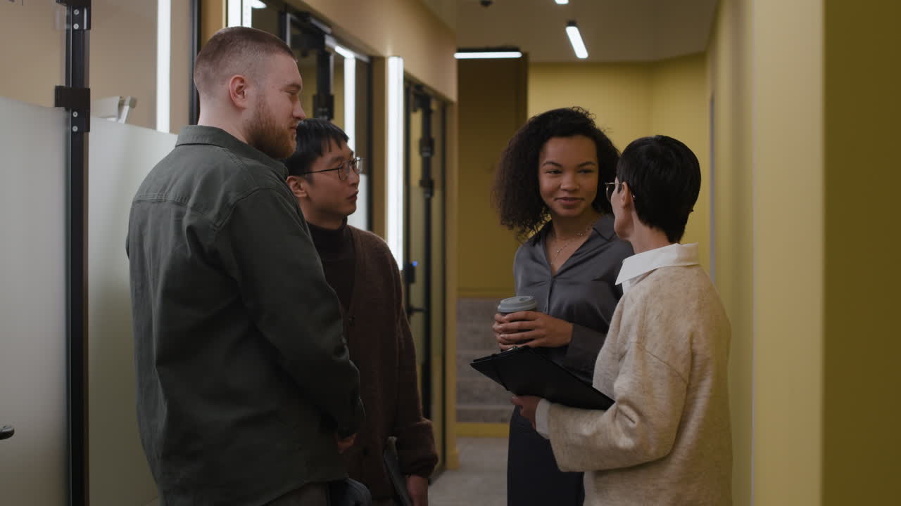 Group of coworkers discussing in an office hallway