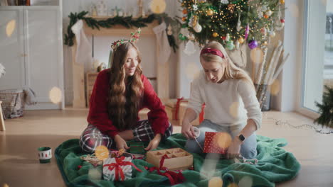 beautiful sisters wrapping christmas presents at home