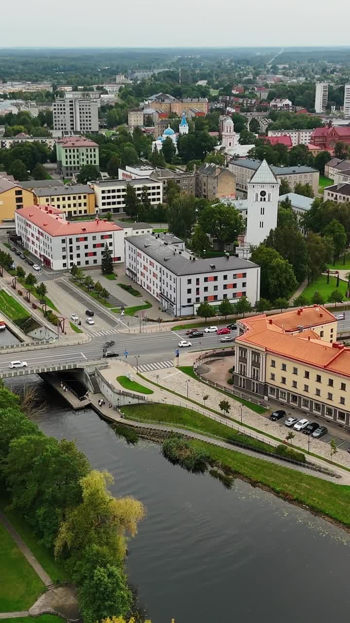 Vertical drone view of Jelgava with river, bridge, traffic and historic white tower