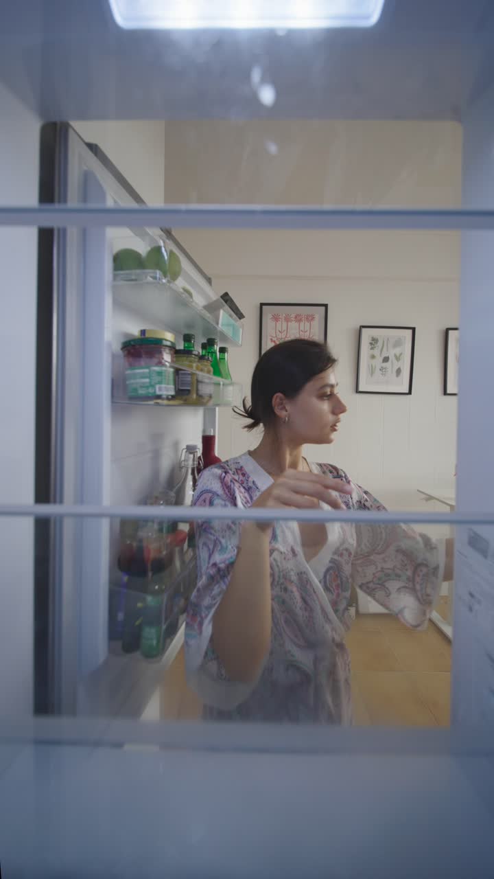 Woman Putting Food Away in the Refrigerator