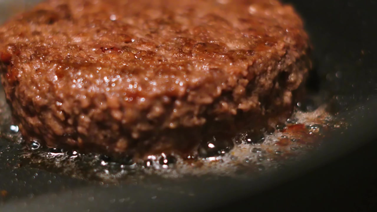 Close Up Macro Shot of Burger Sizzling in Hot Frying Pan. Ideal for Advertising Cooking Products. Making Burgers 4K