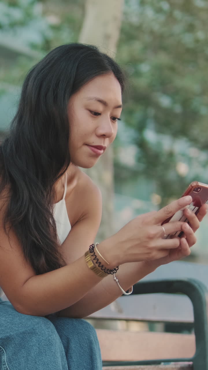 Young woman using cell phone in city