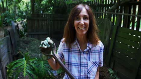 mujer madura usando tenedor de jardinería en el jardín 4k