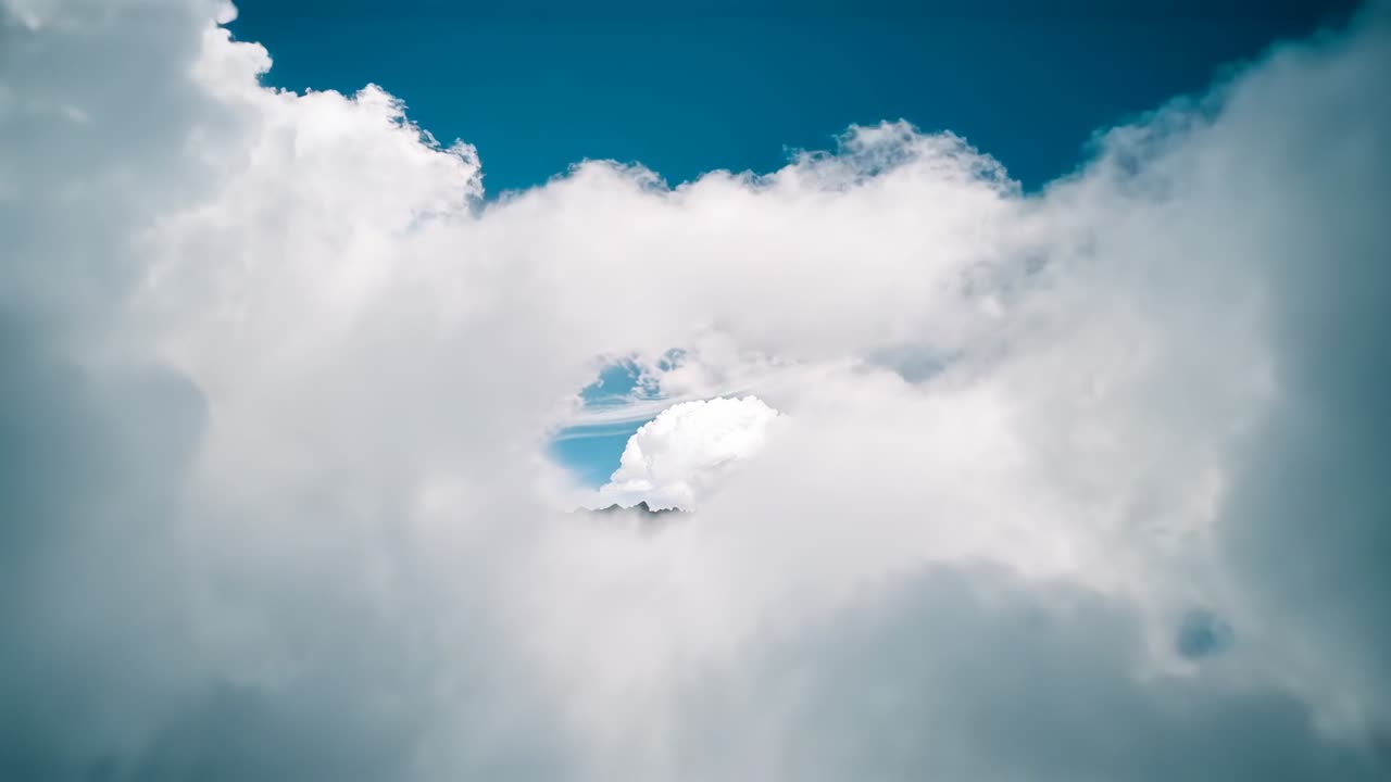 Sunlight outlining cumulus bank widening center gap from cloud deck, showing contrail and speck