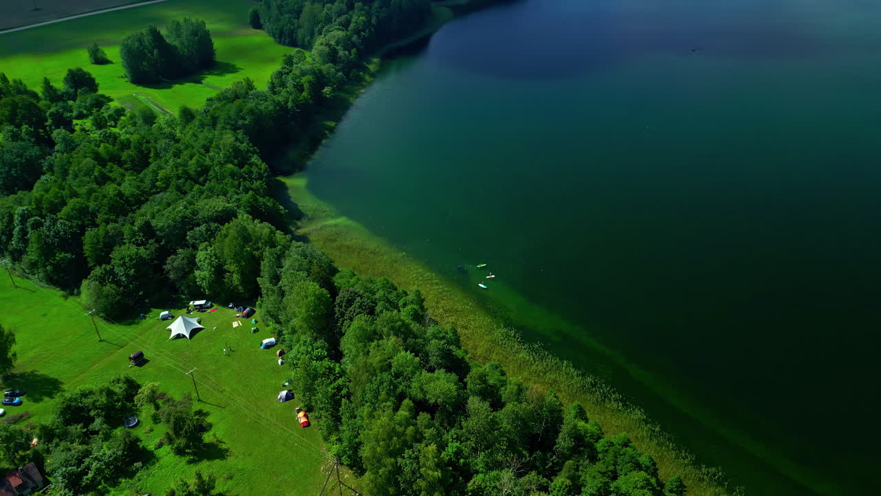 푸른 숲 속 의 아름다운 호수, 호수 연안 에 있는 사람 들 이 캠핑 하고 배 들
