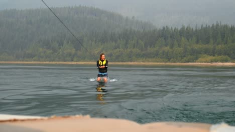 Front-view-of-caucasian-young-man-doing-tricks-on-wakeboard-in-the-city-river-4k