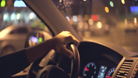 el hombre conduciendo un coche en la ciudad nocturna