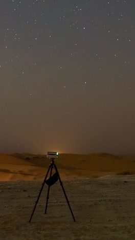 a star gazing party in the al qua'a desert of abu dhabi landscape under a starlit sky, with people observing the rising milky way core with a smart telescopes - vertical time lapse