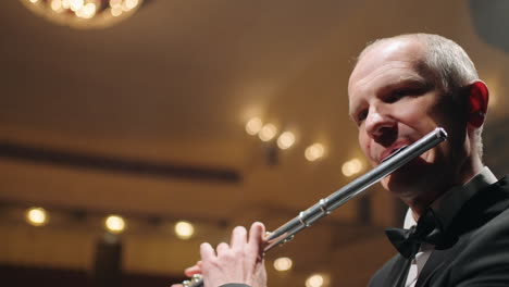 flutist-is-playing-music-on-scene-of-opera-house-or-philharmonic-hall-closeup-portrait