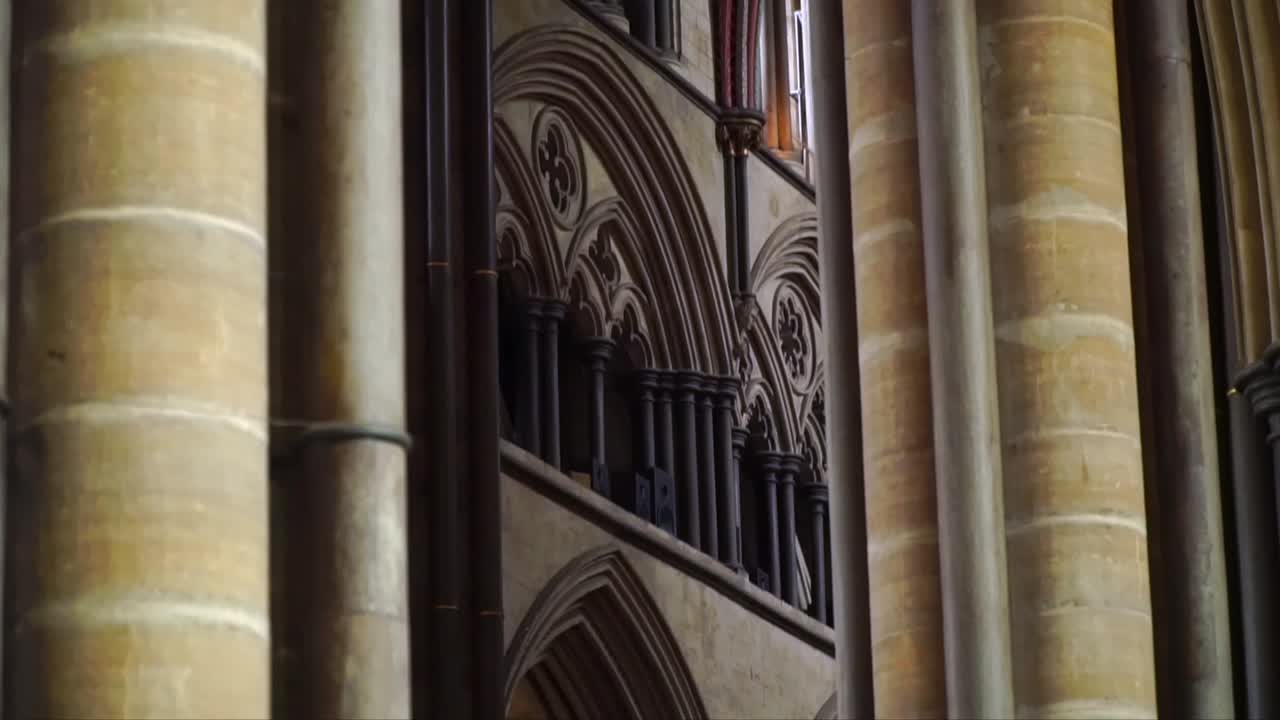Close-up of Gothic interior architecture at Salisbury Cathedral, England, featuring stone columns, pointed arches, and intricate medieval design in a historic church setting.