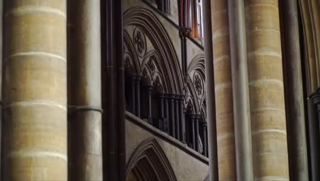 Close-up of Gothic interior architecture at Salisbury Cathedral, England, featuring stone columns, pointed arches, and intricate medieval design in a historic church setting.