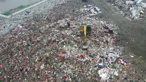 garbage landfill with workers and machinery