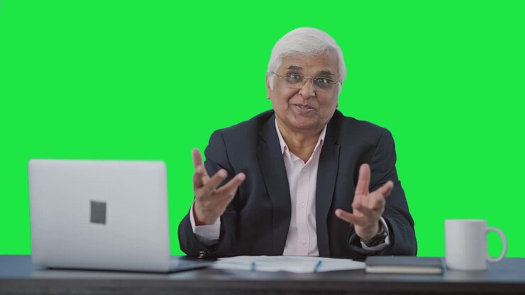 Happy senior Indian businessman talking to someone Green screen