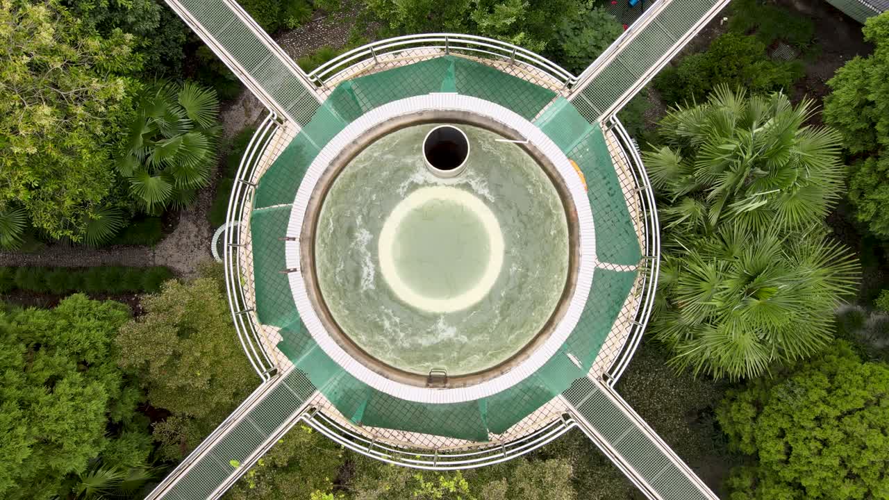 vista aérea de un avión no tripulado de una planta de tratamiento de aguas residuales con tanques de almacenamiento, árboles