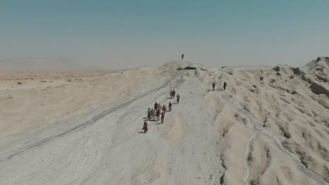 turistas caminando por el lado del volcán de lodo en pakistán
