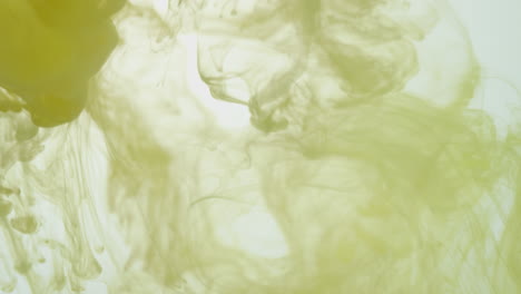 yellow paint or dye dropped into water against white background to create swirling colourful smoke background 3