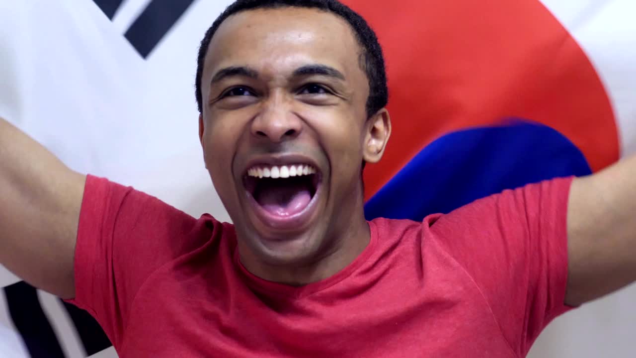 한국 팬이 느린 동작으로 한국의 발을 들고 축하합니다.