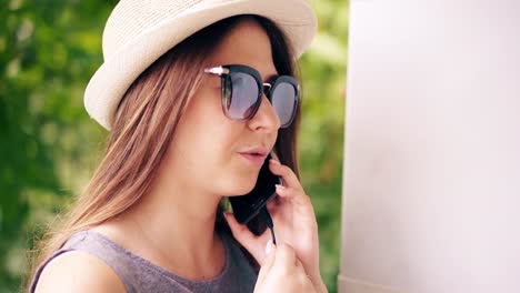 Close-up-Joven-Linda-Chica-Morena-Con-Gafas-De-Sol-Hablando-Por-Teléfono-Móvil