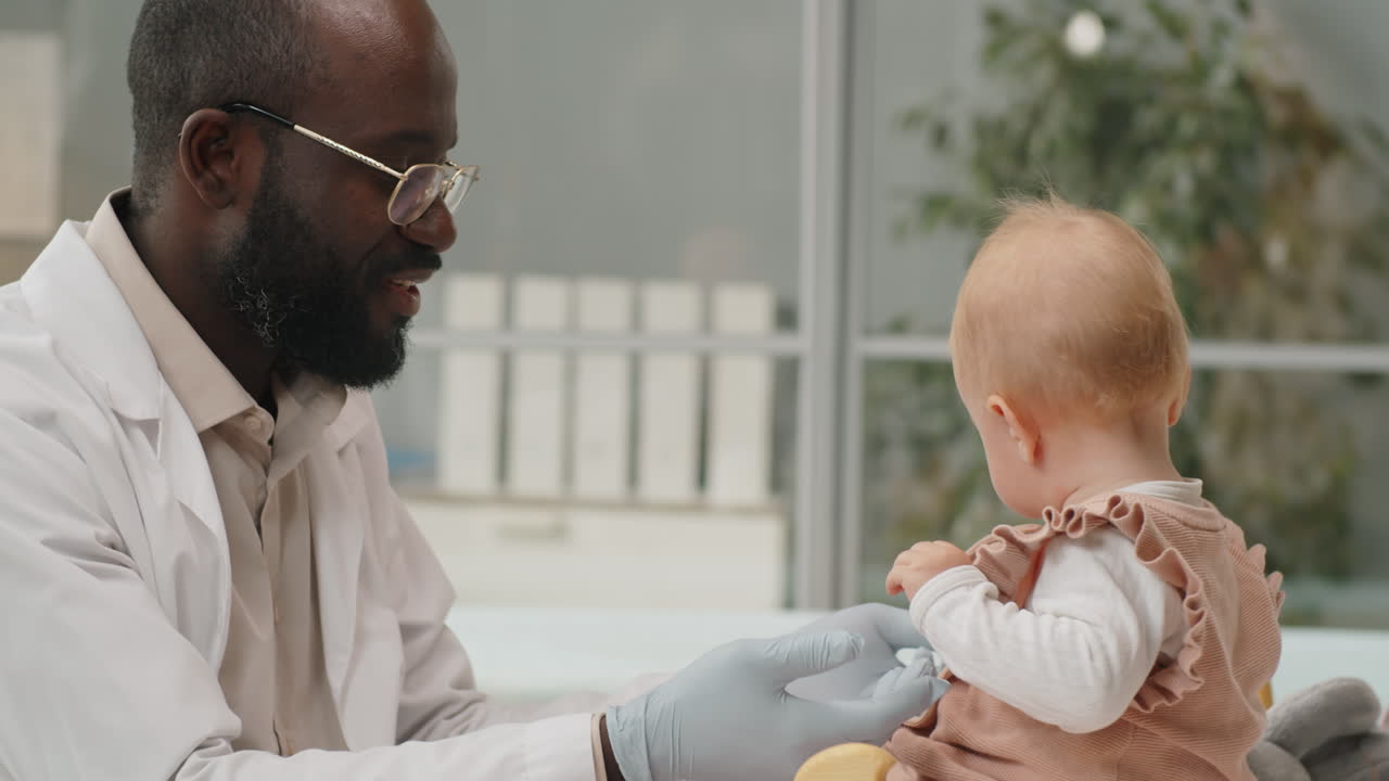 Caucasian Baby on Health Checkup with African American Pediatrician