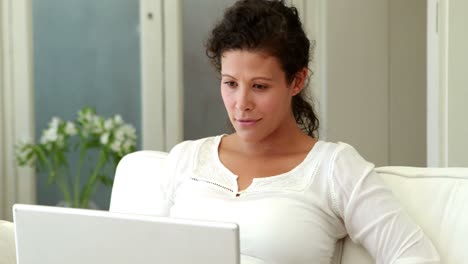 Mujer-Embarazada-Relajándose-En-El-Sofá-Usando-Una-Computadora-Portátil