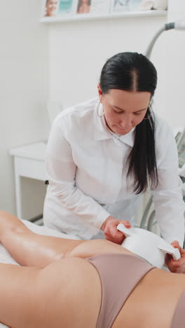 kosmetikerin macht frau kavitation lpg vakuum-roller-massage auf beinen korrektur zahlen in der klinik
