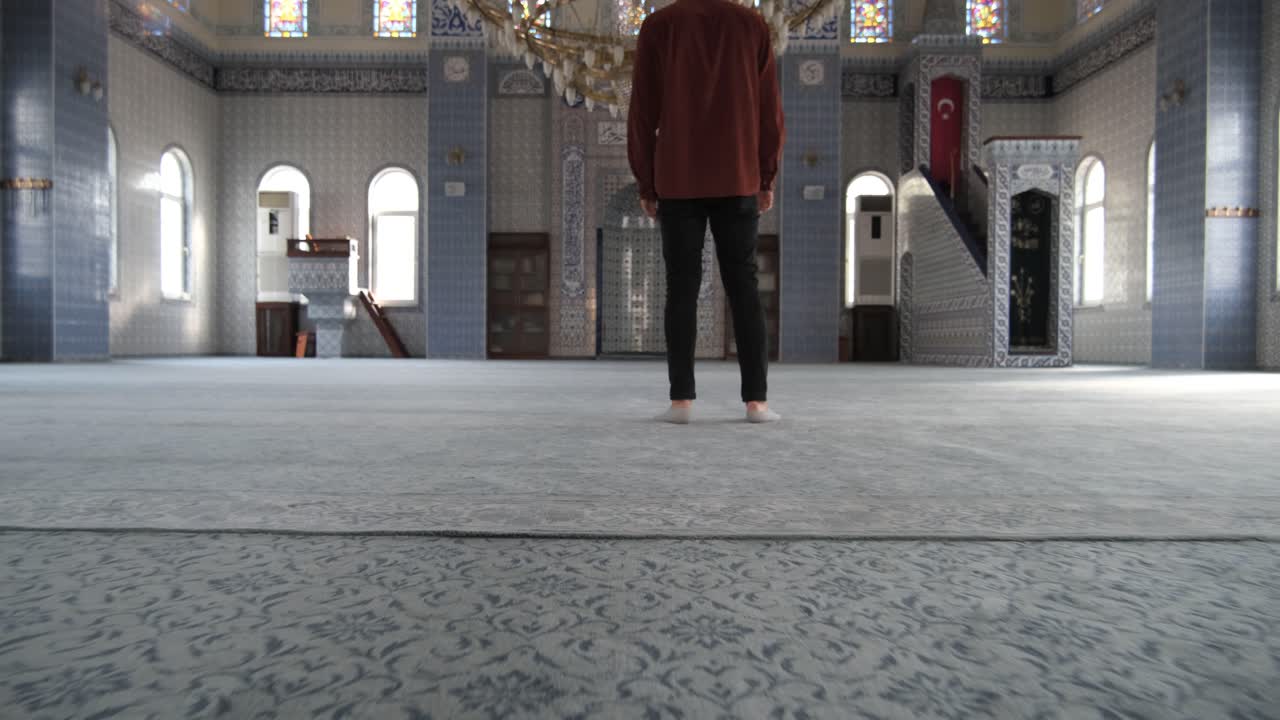 A young man walks through the mosque door, people visit historical and cultural places of worship, an old historical mosque