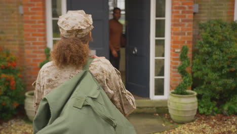 american female soldier returns home to family on leave hugging husband outside house