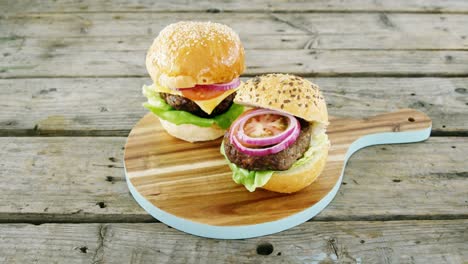 two hamburgers on chopping board