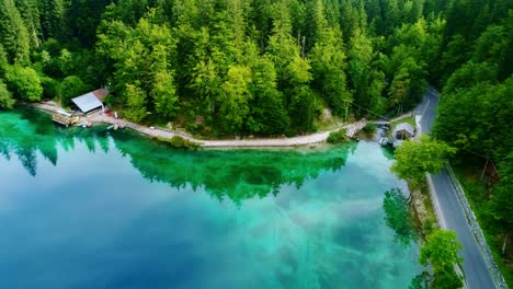 stunning lago di fusine with turquoise waters, dense green forest, drone, italy