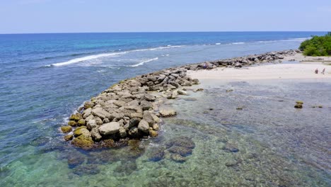 Aerial-view-of-rocky-shore-and-tropical-sandy-beach-during-sunny-day-on-Dominican-Republic