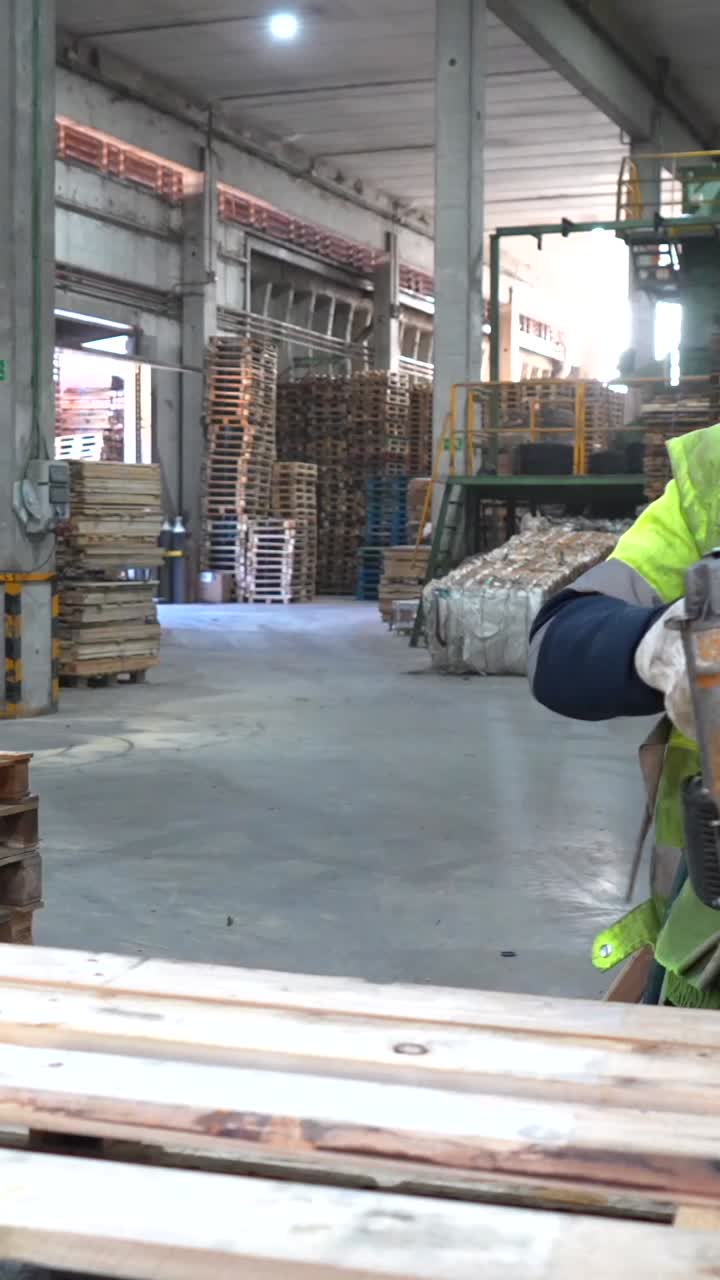Man using a nail gun to build pallets