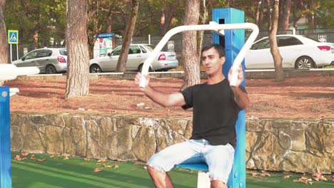 hombre trabajando en un gimnasio al aire libre en el parque