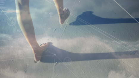 animation of globe over woman walking along the beach