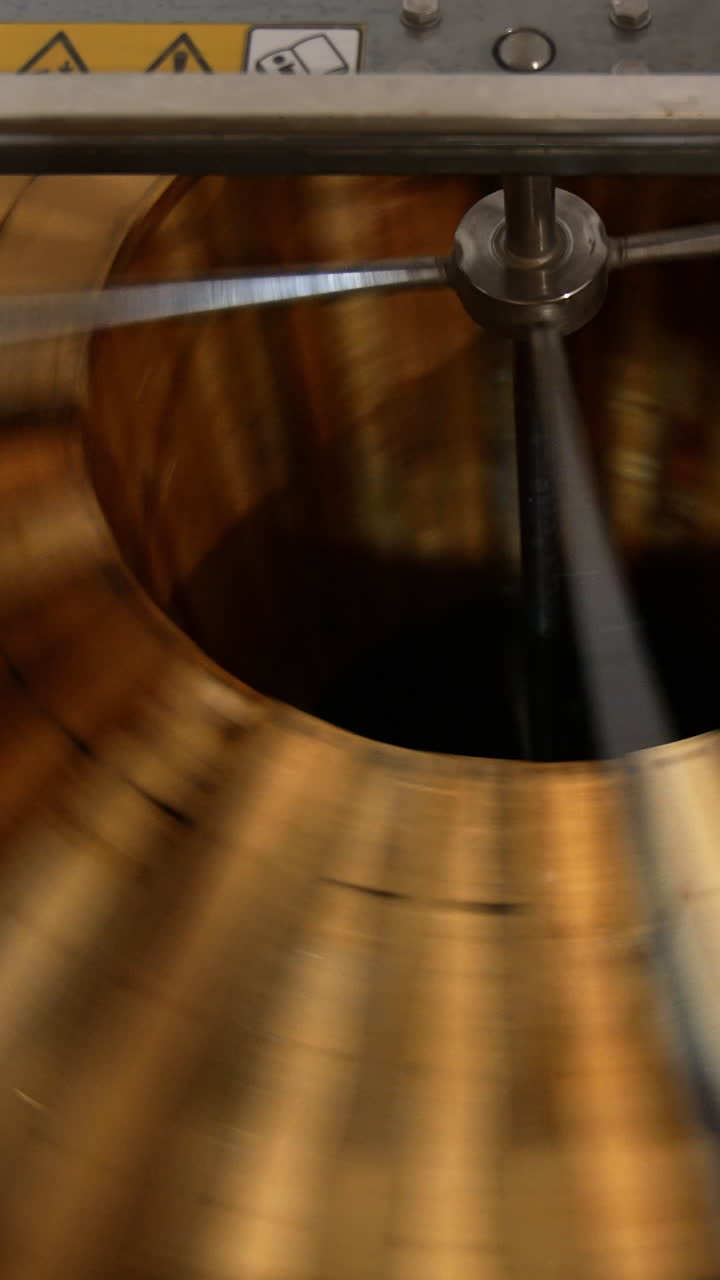 Honey frames rotated in the honey extractor machine. Close up. Top view. Apiarist's equipment for producing organic honey. Vertical video